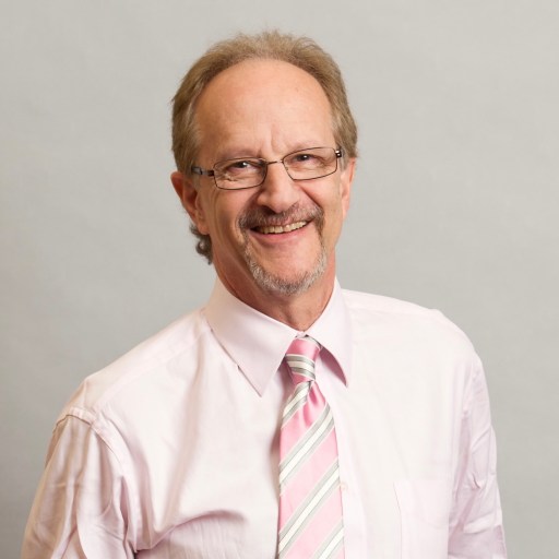 A man in a pink shirt and a pink and white tie.