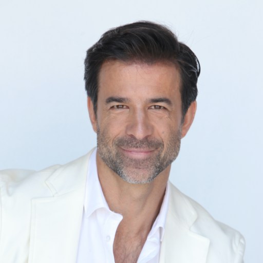 A man wearing a white jacket and white shirt.