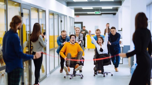 Office team plays a game of chair races to keep their spirits up.