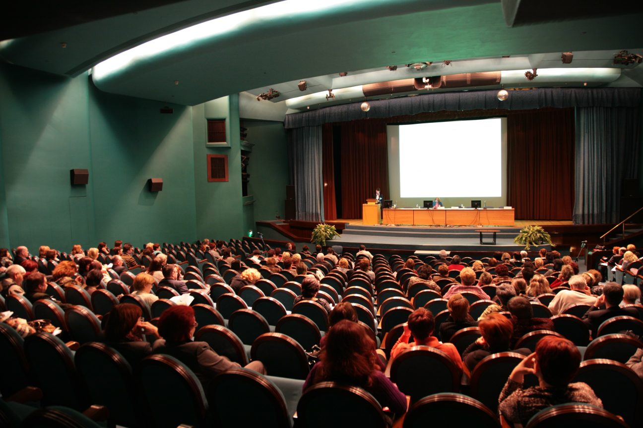 Students listen to a lecture in a college auditorium.