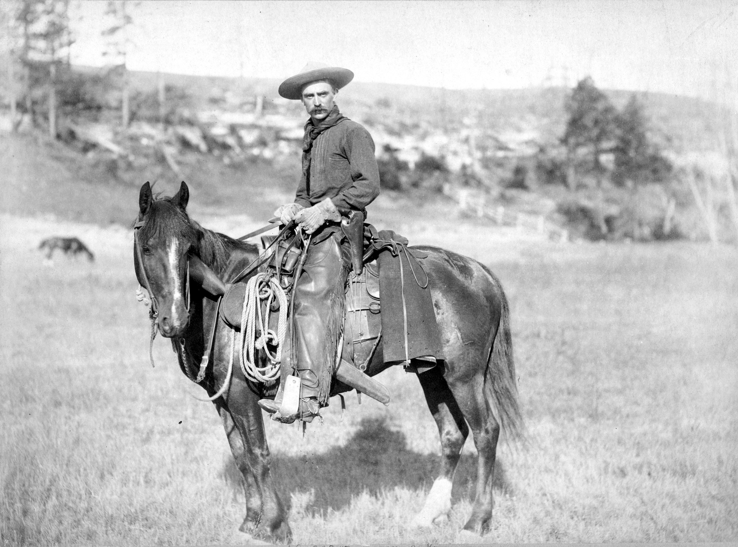 A black-and-white photo of a man on a horse