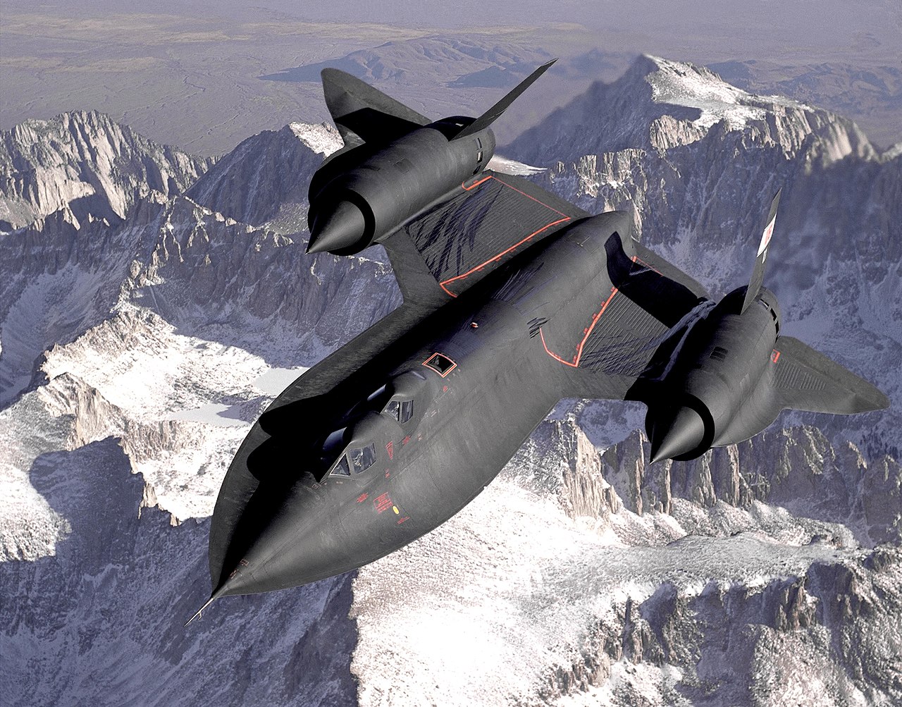 a fighter jet flying over a mountain range.
