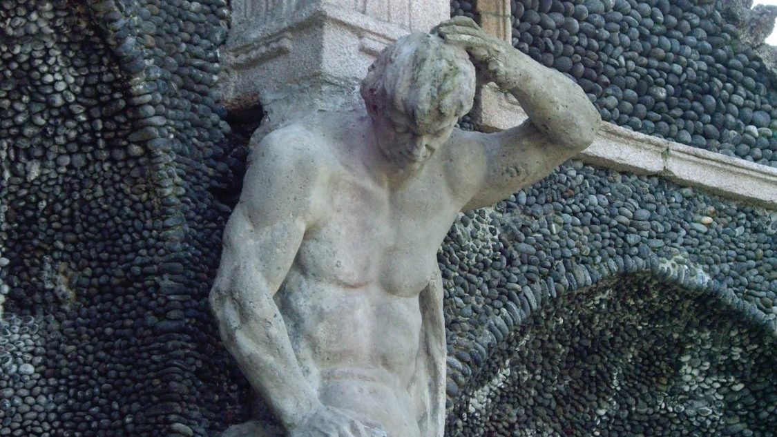 a statue of a man scratching his head