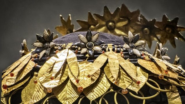 a close up of a hat with gold leaves on it.