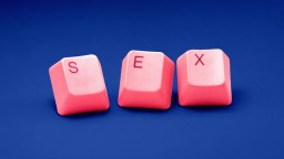 a pink computer keyboard with the word sex spelled on it.