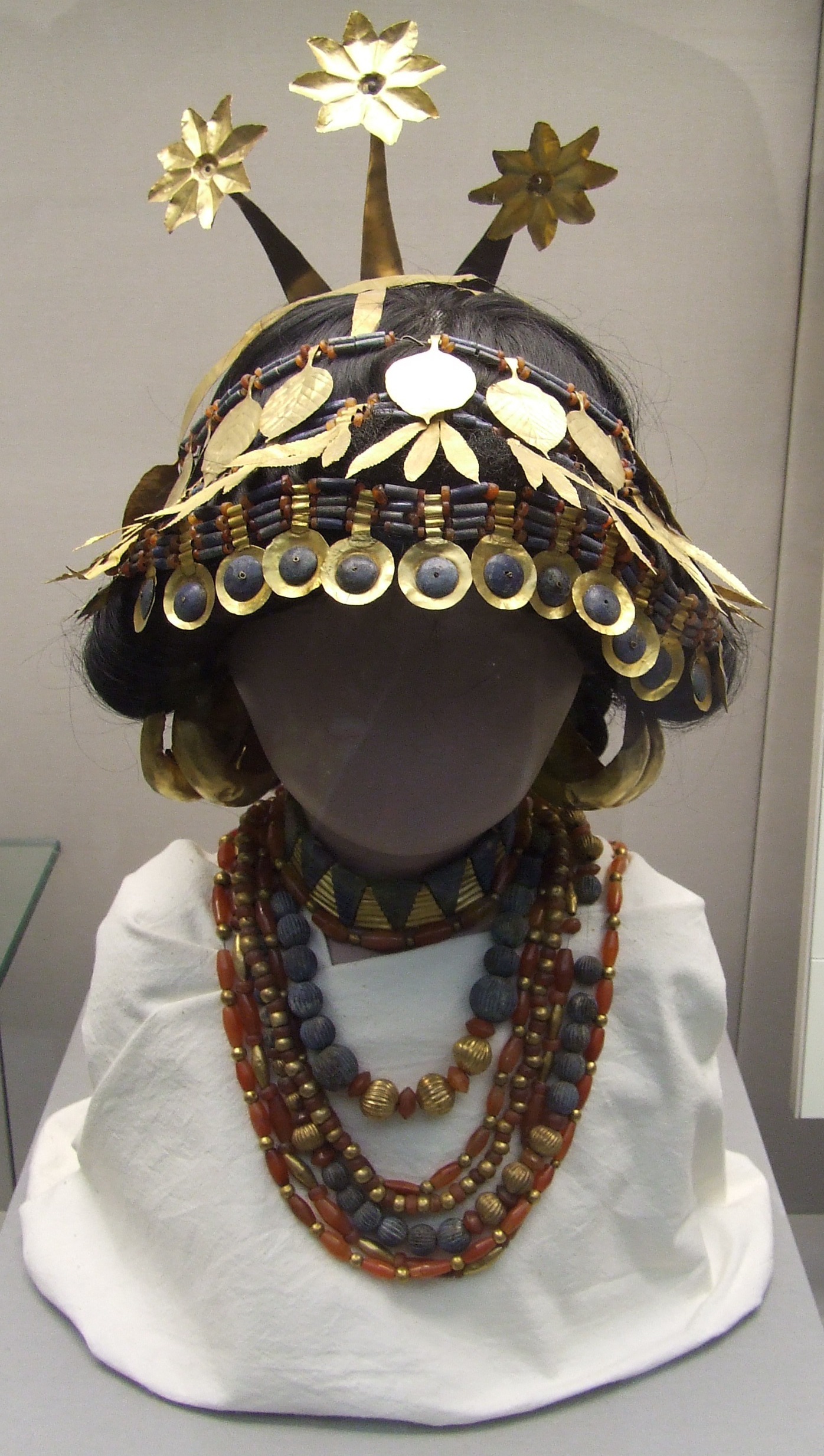 a mannequin wearing a headdress made of metal and beads.