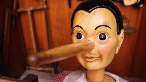 a wooden dummy with a wooden stick sticking out of it's mouth.