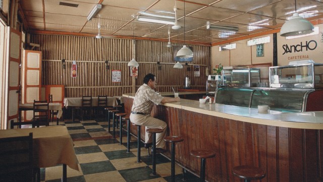 A man sitting at a counter in a restaurant with friends.