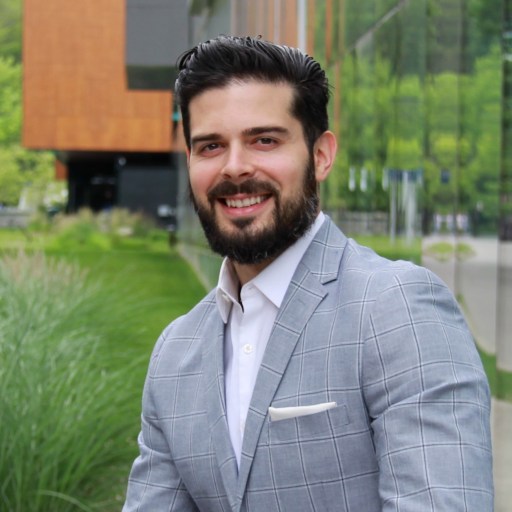 a man with a beard wearing a gray suit.