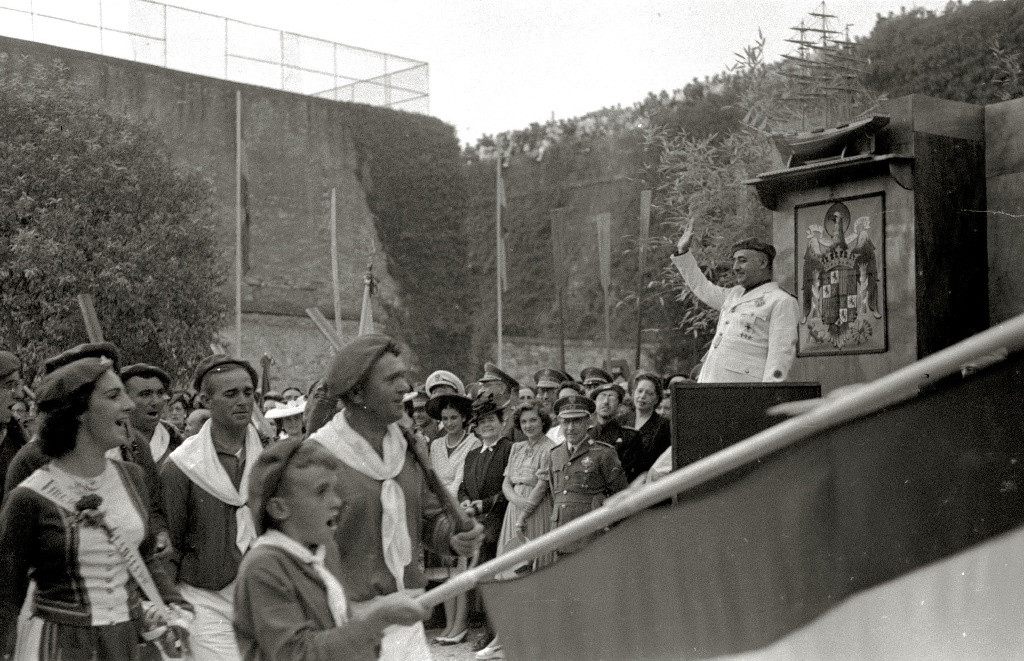 a crowd of people watching a man giving a speech.