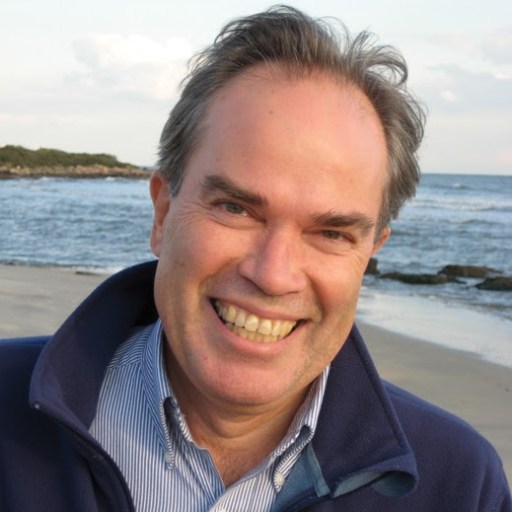 A man with a smile on his face on a beach.