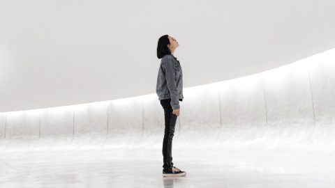 a person standing in a room with a white wall.