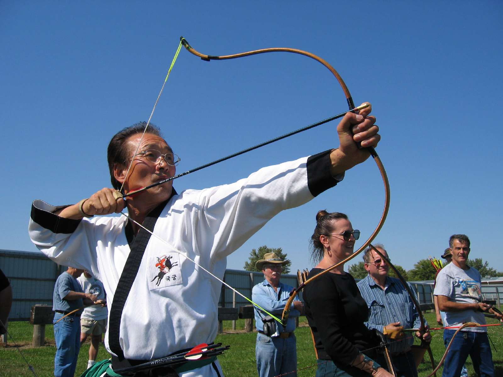 a man holding a bow and arrow in a field.