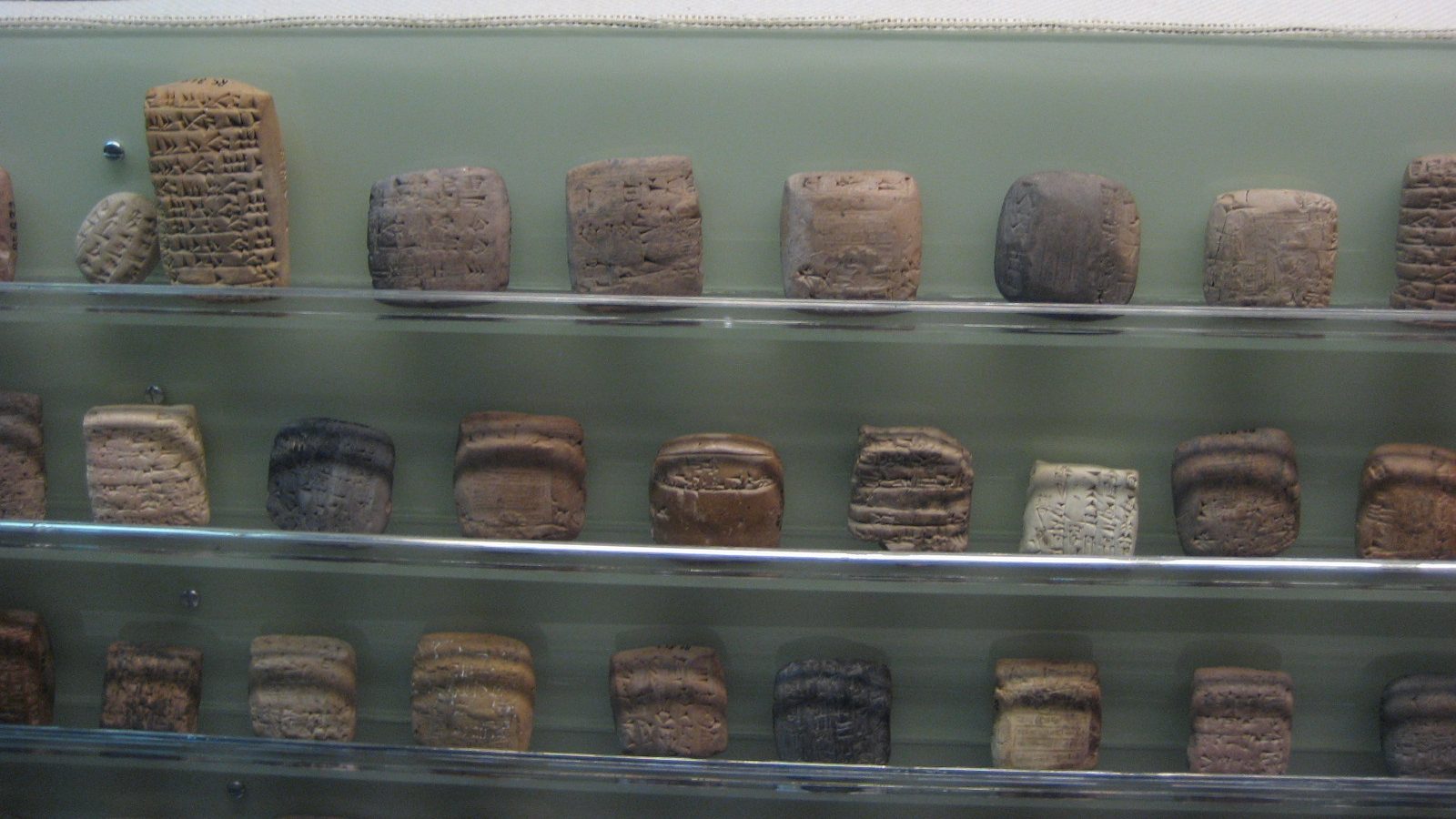 A display case with a lot of different cuneiform tablets.