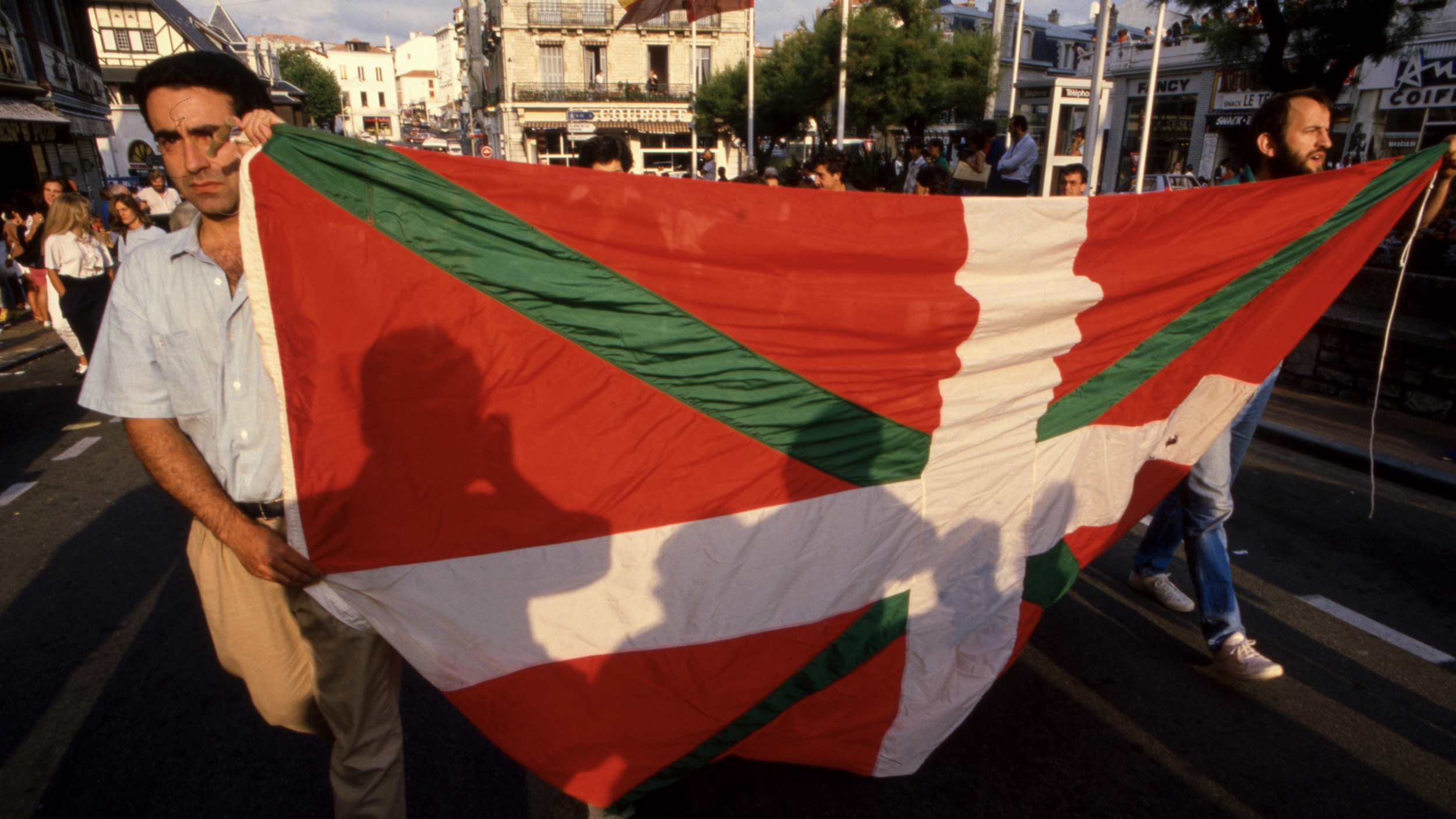 a man holding a large red, green and white flag.