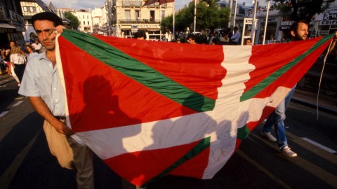a man holding a large red, green and white flag.