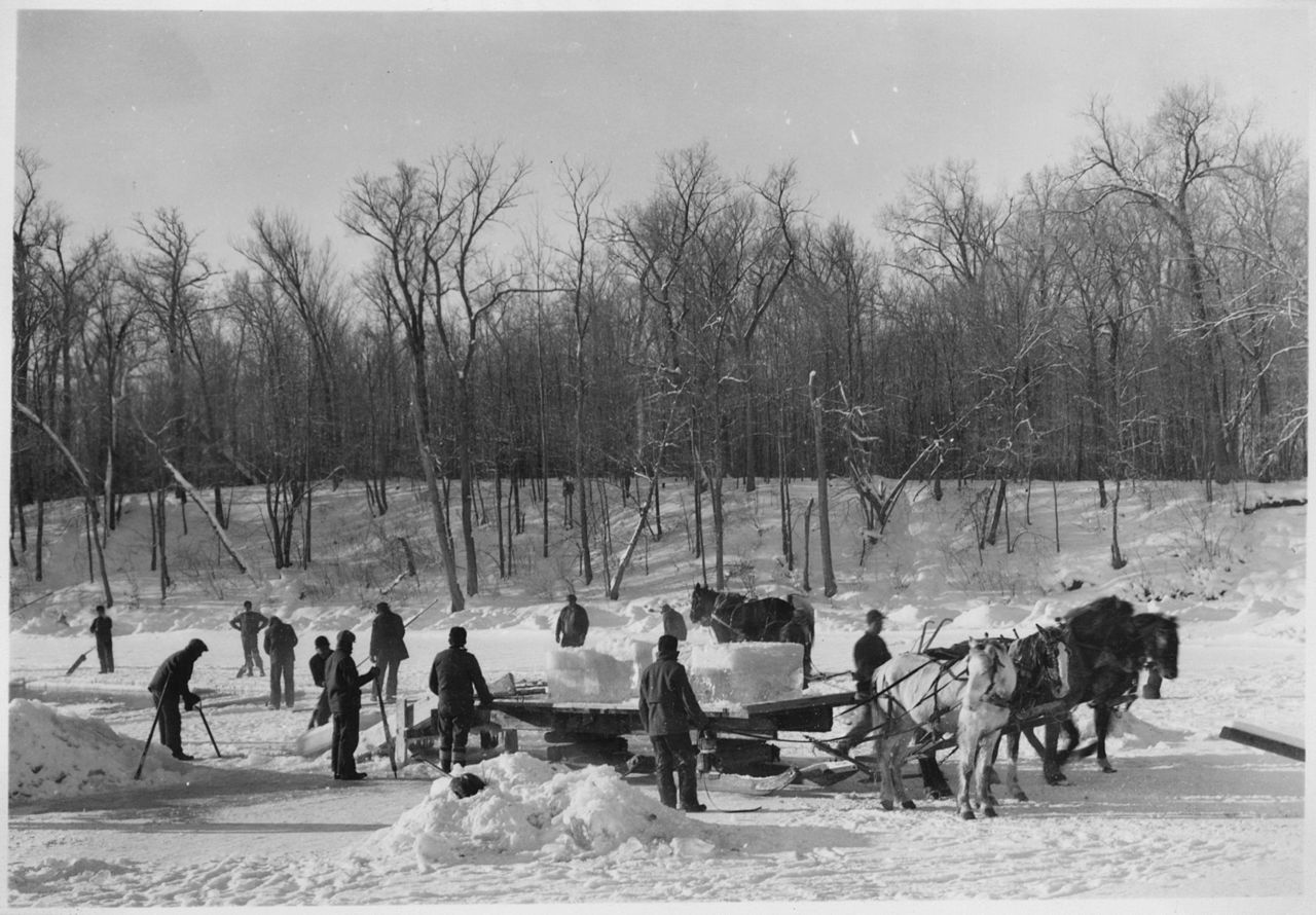 A black and white photo of people working in the snow.