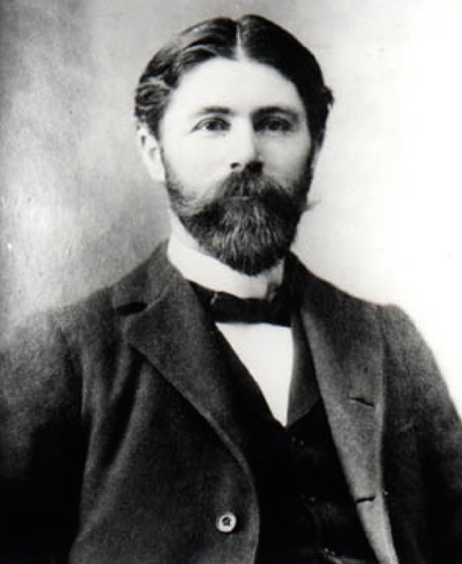 A black and white photo of a man with a beard.