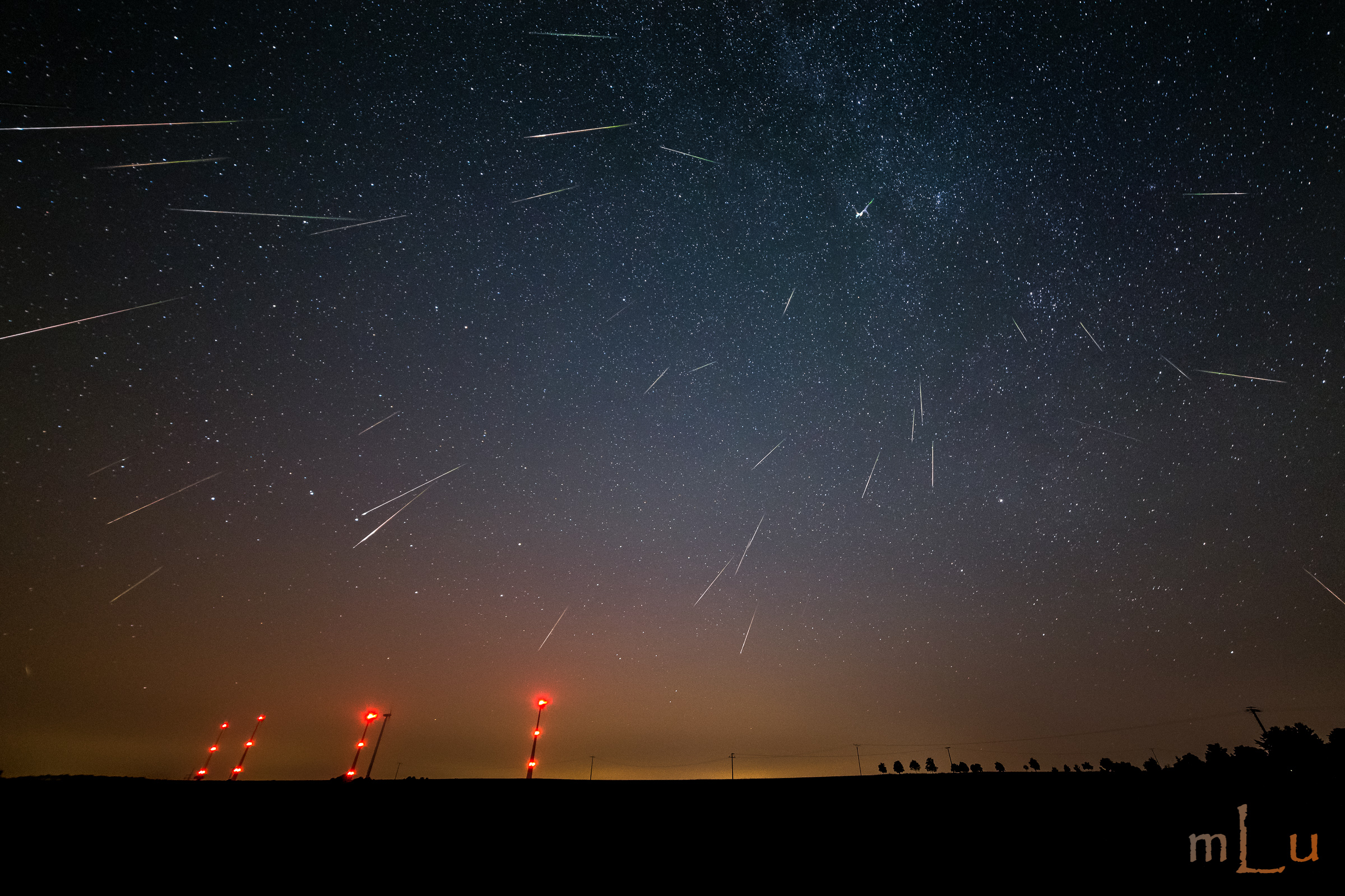 A night sky filled with numerous shooting stars during the Perseid meteor shower.