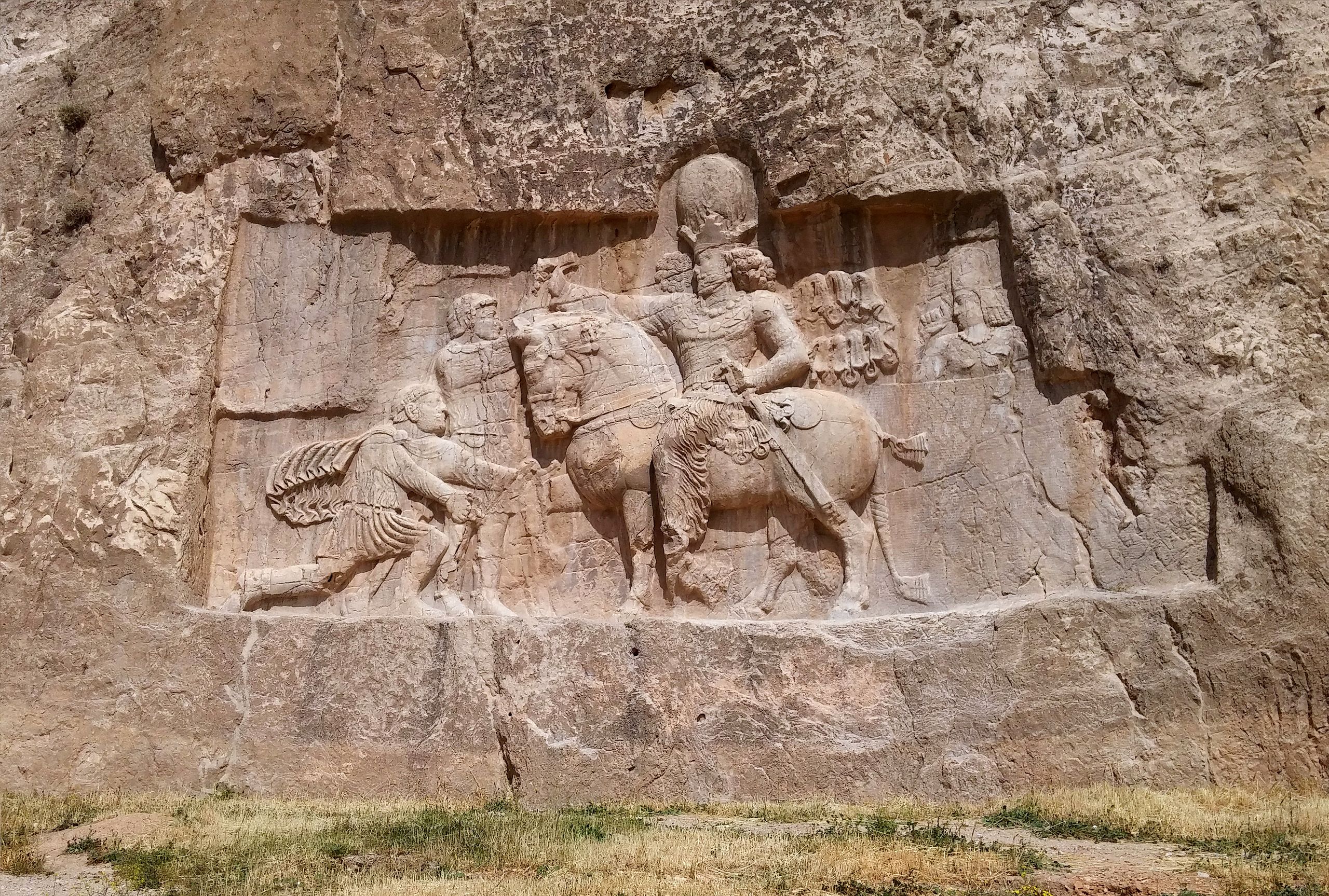 A relief depicting a man riding a horse on a rock.