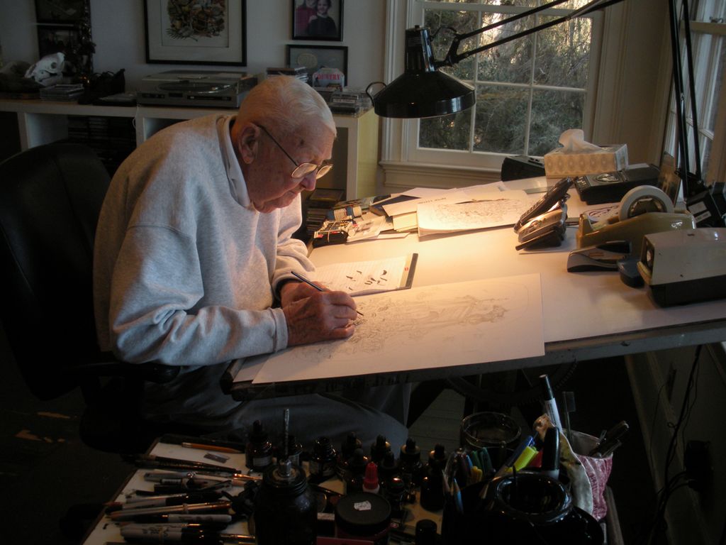 A man is drawing at his desk.