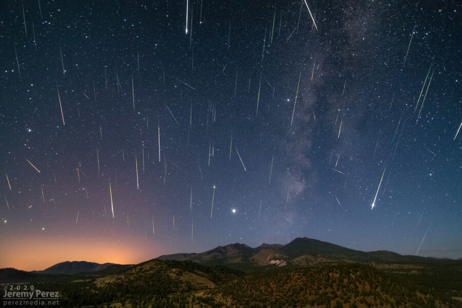 A celestial spectacle featuring the Perseid meteor shower against a majestic mountain backdrop.