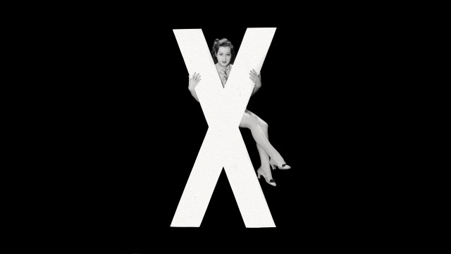 A woman poses in front of the letter x in a black and white photo.