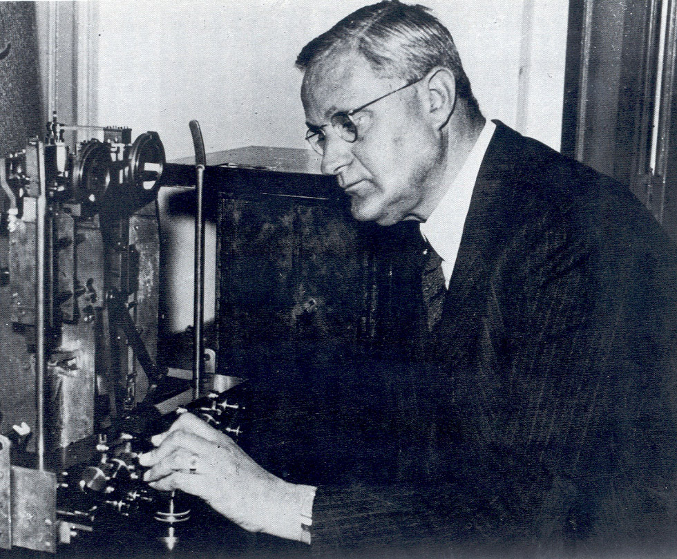 A man in a suit working on a machine.