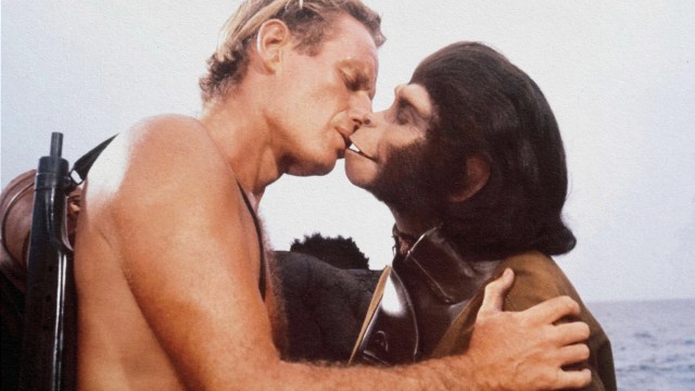 A man and a monkey named Ivanov kissing in the ocean.