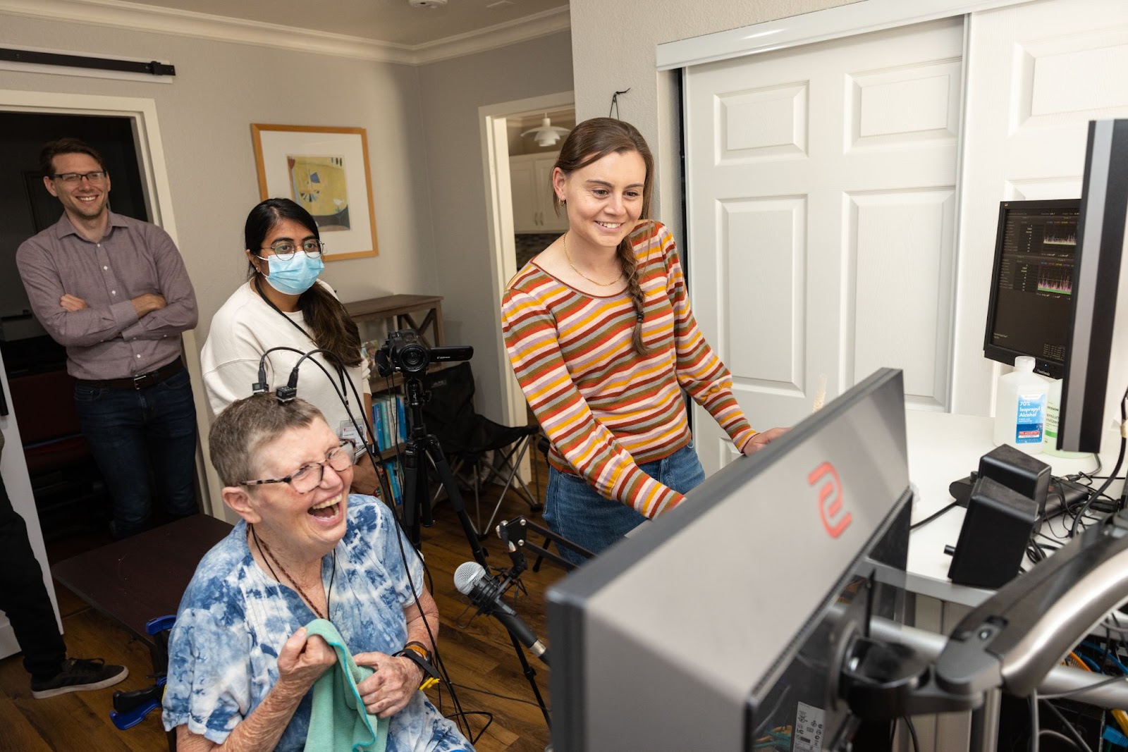 A group of people standing in front of a computer.