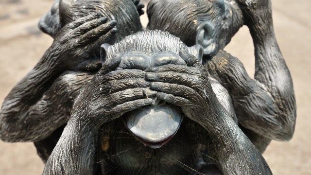 A statue of three monkeys covering their faces.