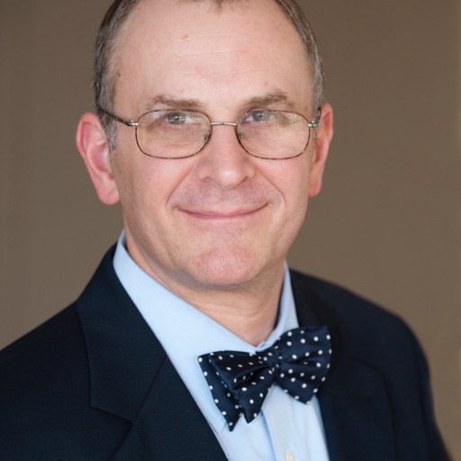 A man wearing glasses and a bow tie.