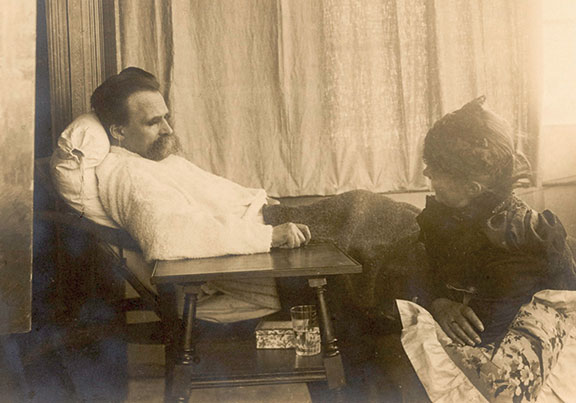 An old photo depicting Friedrich Nietzsche and a woman sitting in a chair.