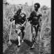 A black and white photo of two men walking down a path in Papua New Guinea.