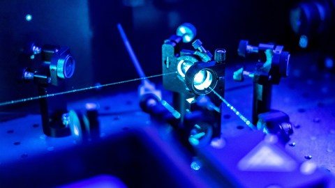 An image of a blue laser in a dark room.