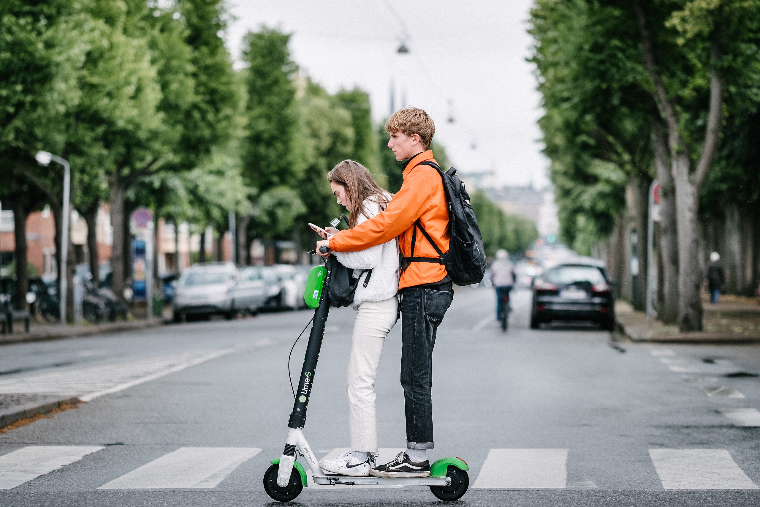 A man and woman riding a scooter