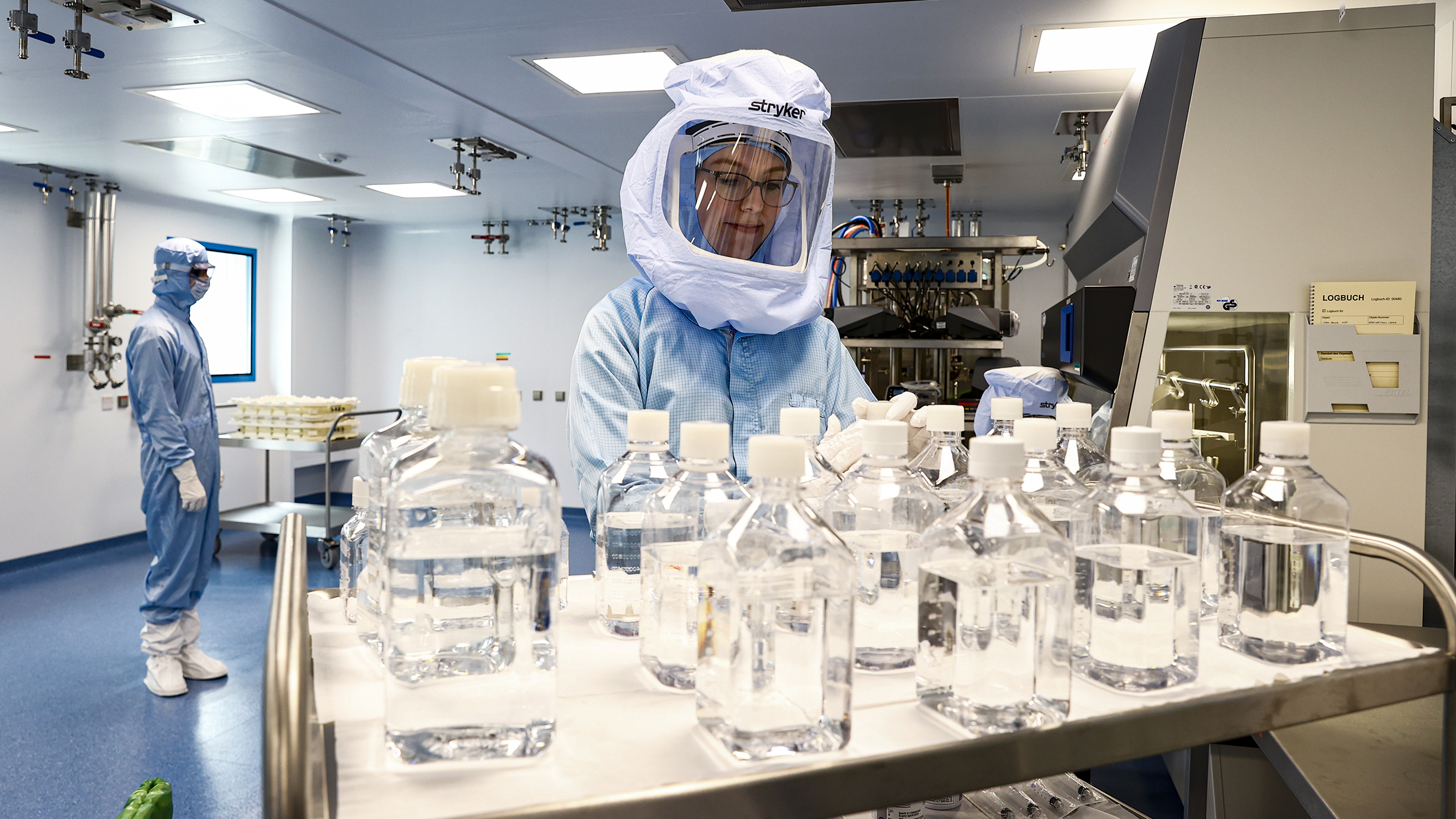 A person in a protective suit working in a mRNA vaccine factory.