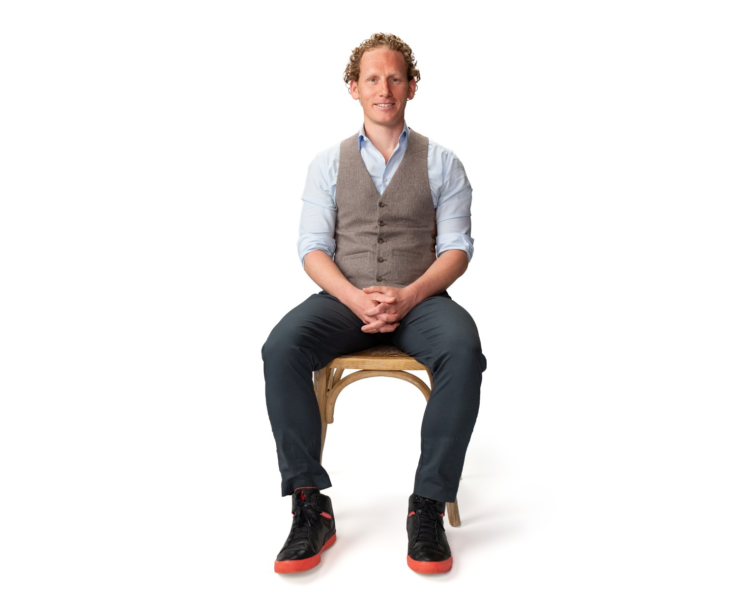 A man sitting on a wooden chair.