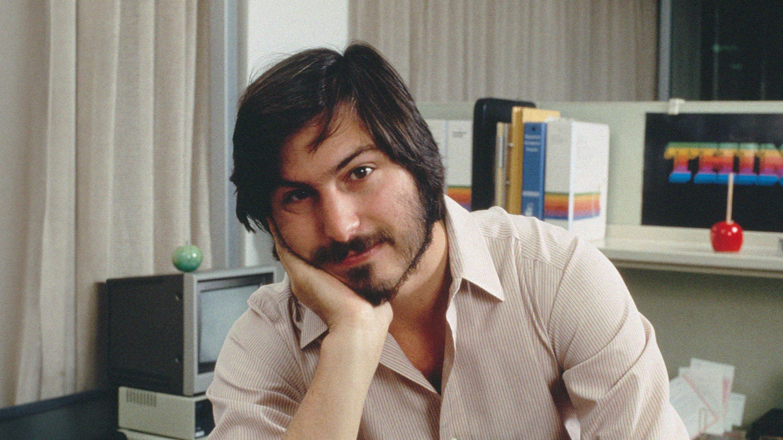 Steve Jobs in his office, showcasing survivorship bias in his journey of founding and leading Apple.