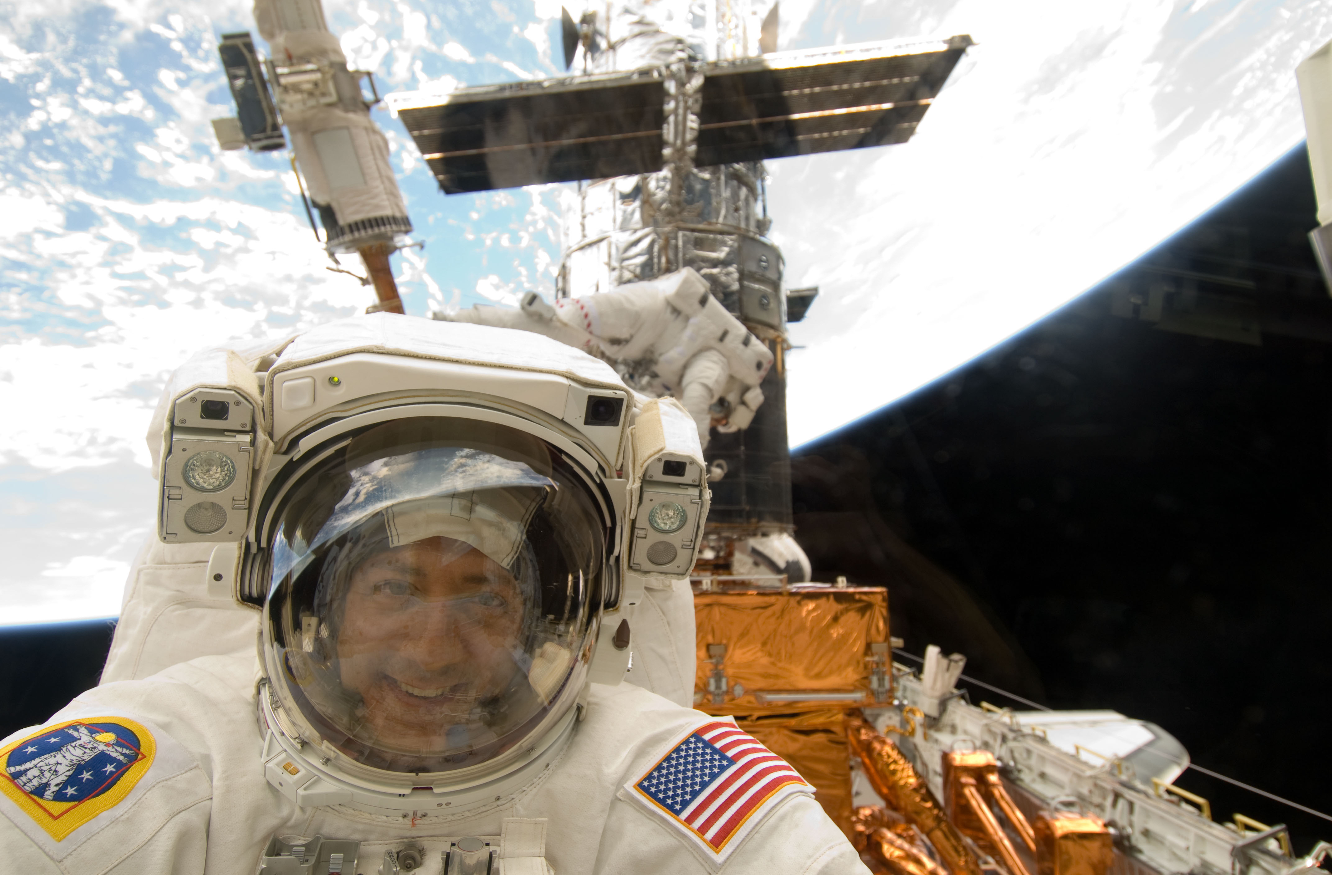 A man in a space suit is taking a selfie.