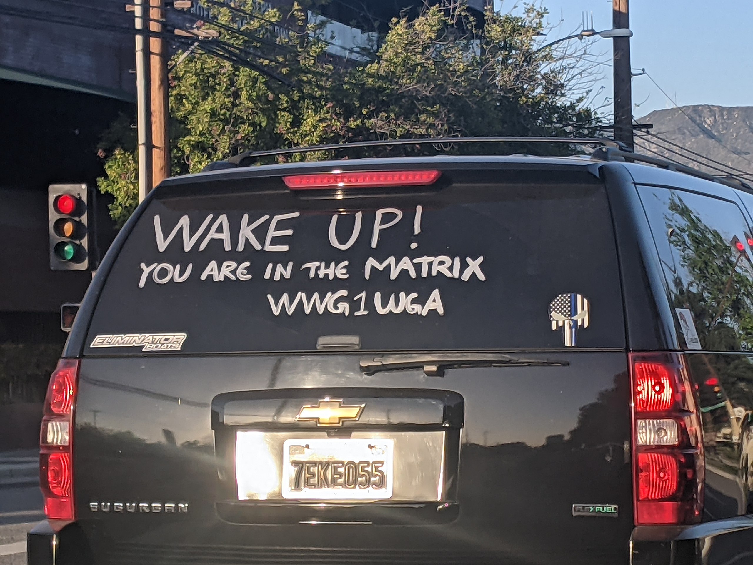A van with a sign that says wake up, inducing paranoia as it hints at the idea of being trapped in the matrix.