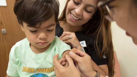 A young boy is getting an RSV injection from a doctor.