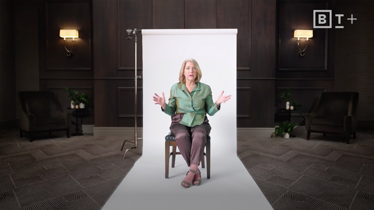 Liz Wiseman sitting on a chair in front of a white backdrop.