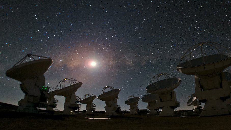 A group of satellite dishes under a starry sky, capturing celestial signals from star birth.