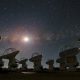 A group of satellite dishes under a starry sky, capturing celestial signals from star birth.