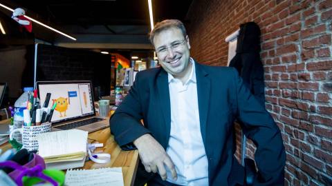 A man utilizing AI for business, sitting at a desk with a laptop.