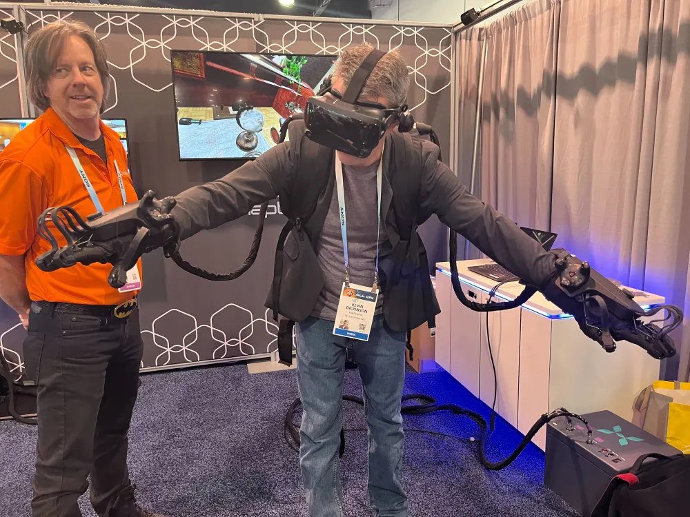 A man wearing a vr headset is standing next to another man.