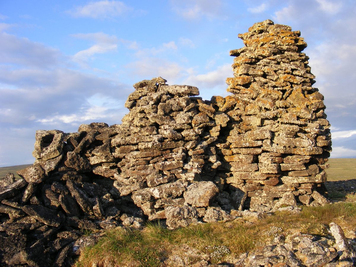 The ruins of a stone structure on top of a hill.