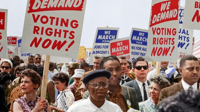 A group of people holding signs that say we demand voting rights now.