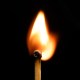 A match stick with a flame on a dark background.